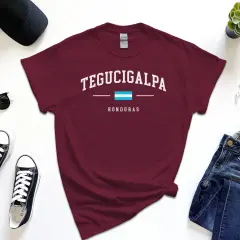 T-shirt z napisem Tegucigalpa, Honduras. Obok czapka, okulary, trampki, jeansy i smartwatch.