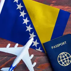 Flaga Bośni i Hercegowiny, paszport i model samolotu na drewnianym tle. Gotowi na podróż do Bośni i Hercegowiny!