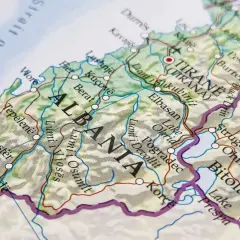 Mapa pokazuje, gdzie leży Albania, z zaznaczonymi miastami jak Tirana, Durrës i Berat, oraz Morzem Adriatyckim.