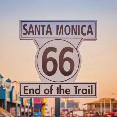 Koniec legendarnej drogi 66 USA w Santa Monica. Znak "End of the Trail" na tle zachodzącego słońca.