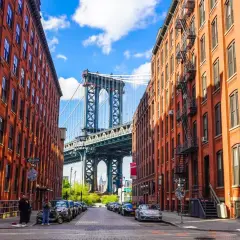 Ulica w dzielnicy DUMBO, Queens, Nowy Jork, z widokiem na most Manhattan Bridge między ceglanymi budynkami.