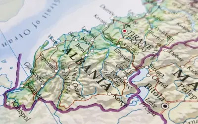 Mapa pokazuje, gdzie leży Albania, z zaznaczonymi miastami jak Tirana, Durrës i Berat, oraz Morzem Adriatyckim.