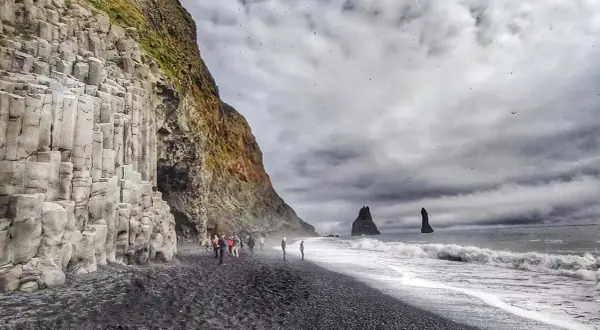 Słynna plaża Reynisfjara z bazaltowymi kolumnami i skalnymi formacjami w morzu.