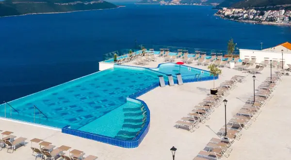 Luksusowy basen z widokiem na morze w Neum, Bośnia i Hercegowina. Leżaki i błękitna woda zapraszają do relaksu.