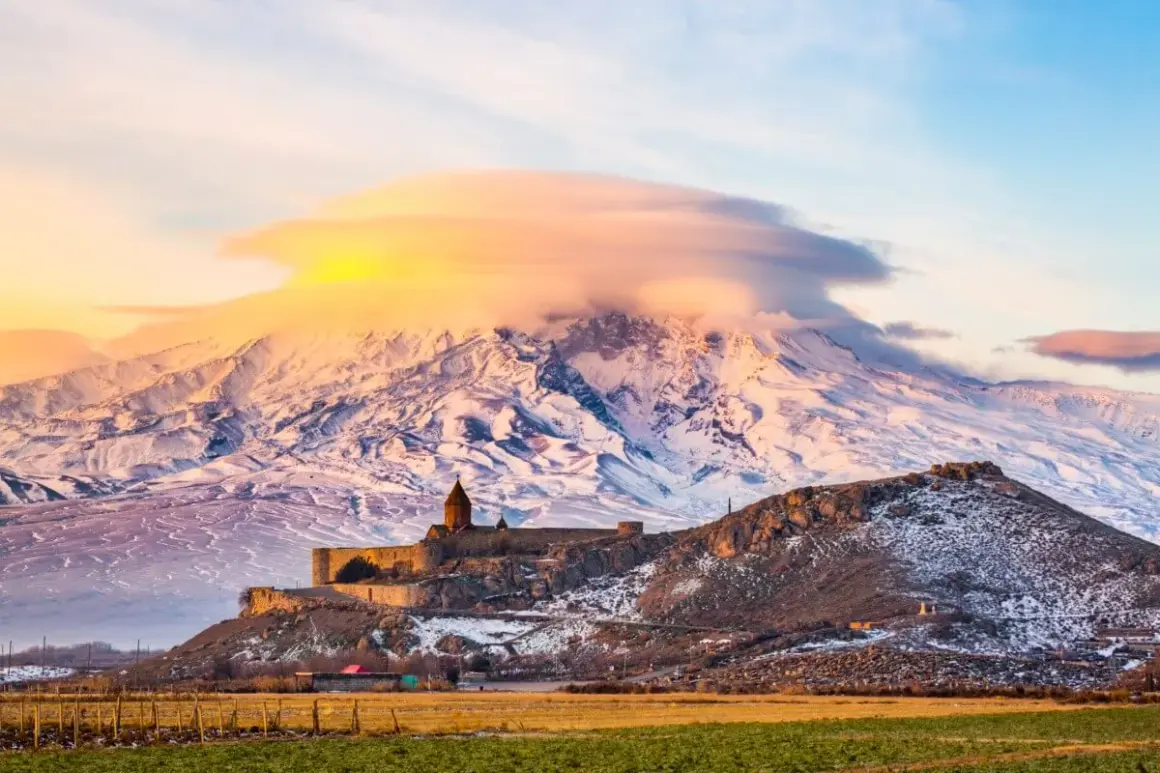 Zimowy krajobraz z klasztorem Khor Virap na wzgórzu, w tle ośnieżony Ararat. Wiza do Armenii może otworzyć drogę do takich widoków.