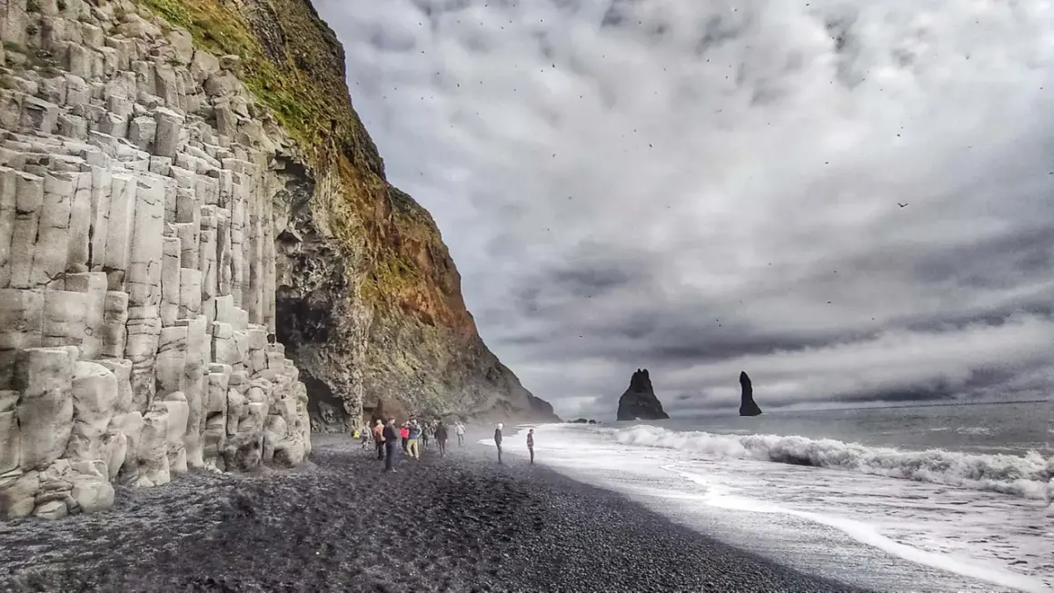 Słynna plaża Reynisfjara z bazaltowymi kolumnami i skalnymi formacjami w morzu.