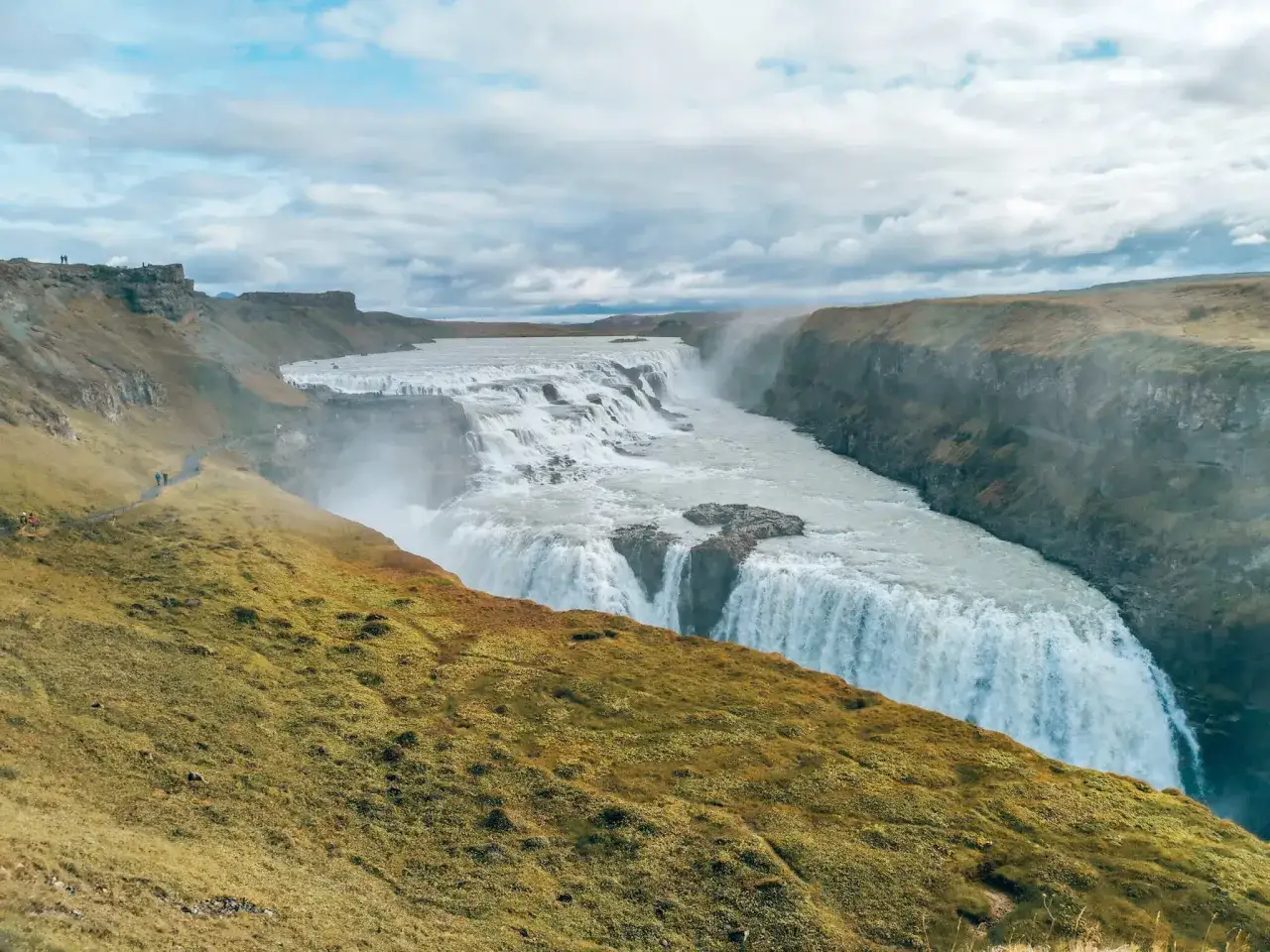 Potężny wodospad Gullfoss na Islandii, tworzący złoty krąg w krajobrazie.