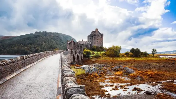 Kamienny most prowadzi do zamku Eilean Donan. Mglisty, jesienny klimat Szkocji podkreśla surowe piękno krajobrazu.